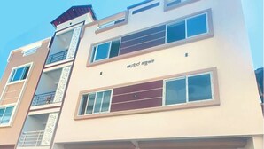 A multi-story building with balconies, large windows, and a sign indicating a business or commercial use.