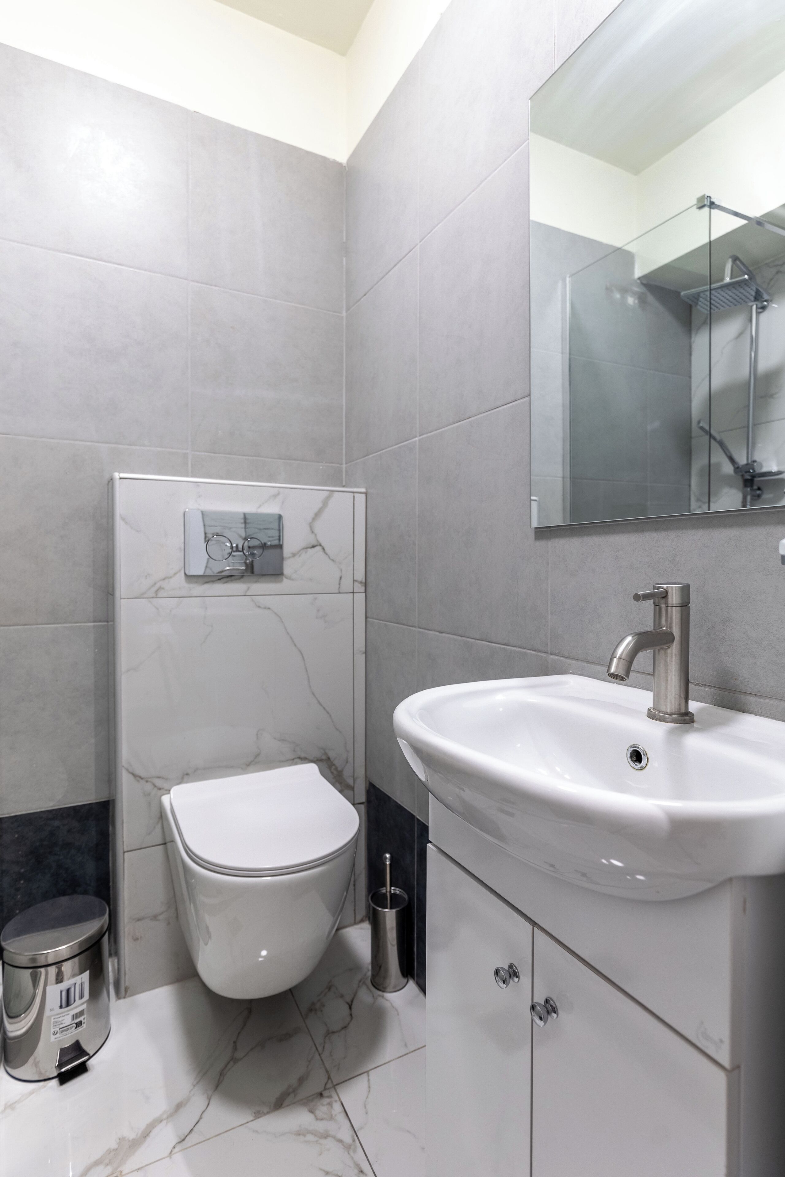 Une salle de bain moderne équipée de toilettes, d’un lavabo et d’un miroir.
