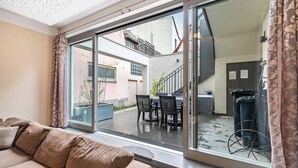 Ein modernes Wohnzimmer mit einem großen Schiebeglastür, die auf eine Außenpatio führt.