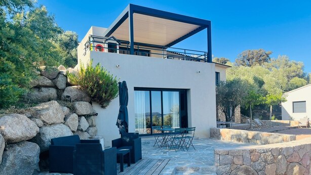 A modern two-story building with a stone facade, outdoor seating area, and a view of the surrounding landscape. - Large 50m2 studio, in the heart of the Maquis, San gavino di Figari (San gavinu Di figari)