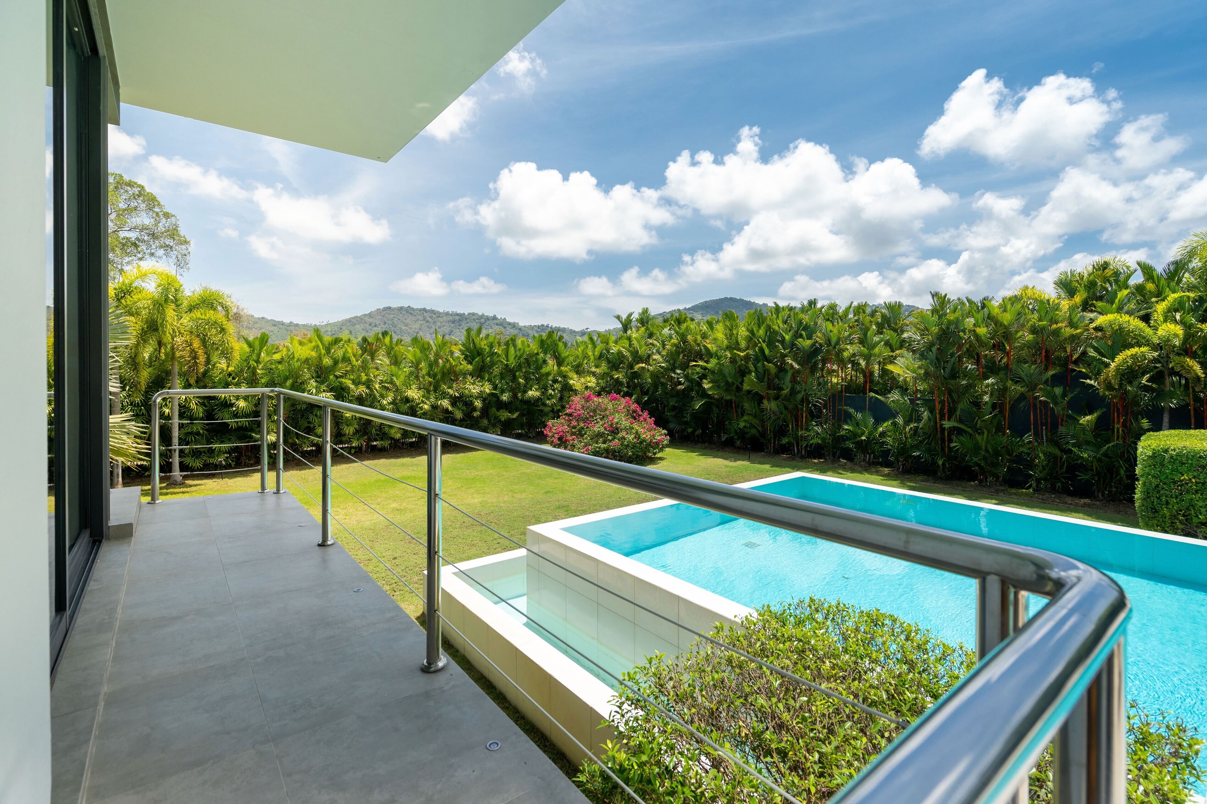 Un espace piscine moderne offrant une vue dégagée sur la végétation luxuriante et les montagnes environnantes.