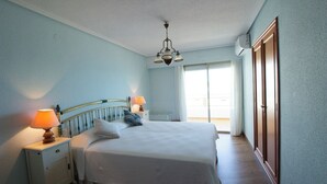 A bedroom with a bed, nightstands, a lamp, a ceiling light, and a sliding door. - EUROMAR - 3 bedroom apartm - Cullera - wifi (Cullera)
