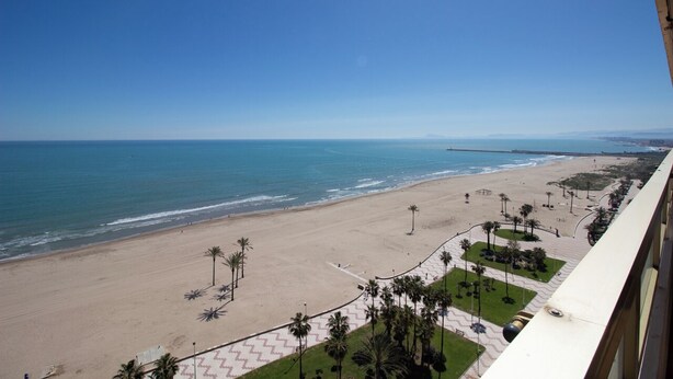 A beach view from a balcony with a clear sky, a sandy beach, and a distant pier. - EUROMAR - 3 bedroom apartm - Cullera - wifi (Cullera)
