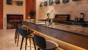 A modern kitchen with a bar area, a fireplace, and contemporary decor. - Rimon Place-Kosher (Venice)