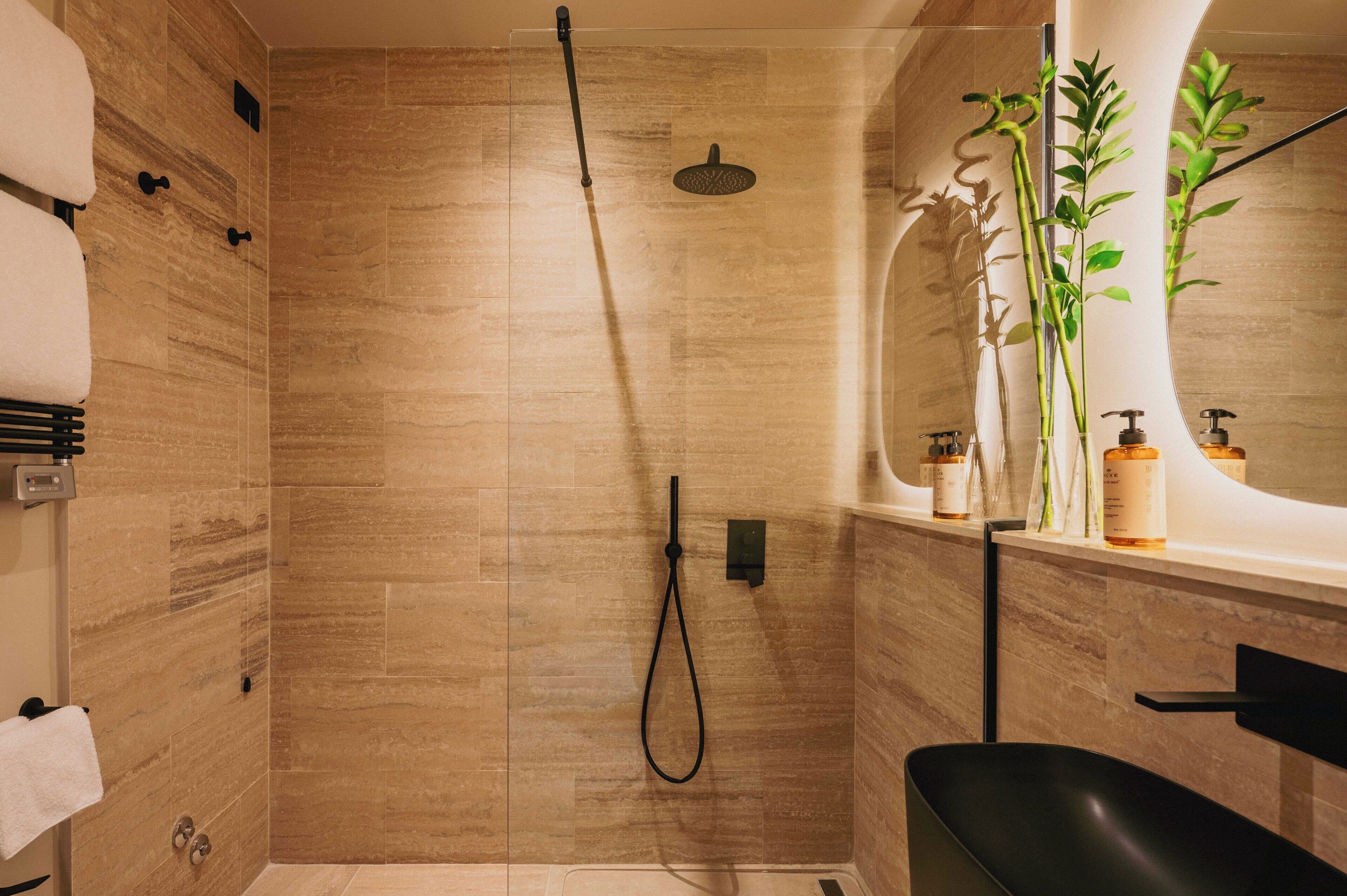 Un baño moderno con ducha, lavamanos y espejo.
