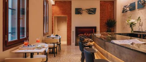 Eine moderne Küche mit Kamin, Bar und Essbereich mit Stühlen und Tisch.