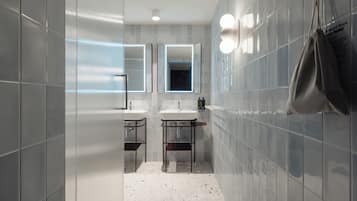 Un baño moderno con dos lavamanos, un espejo y una toalla colgada en la pared.