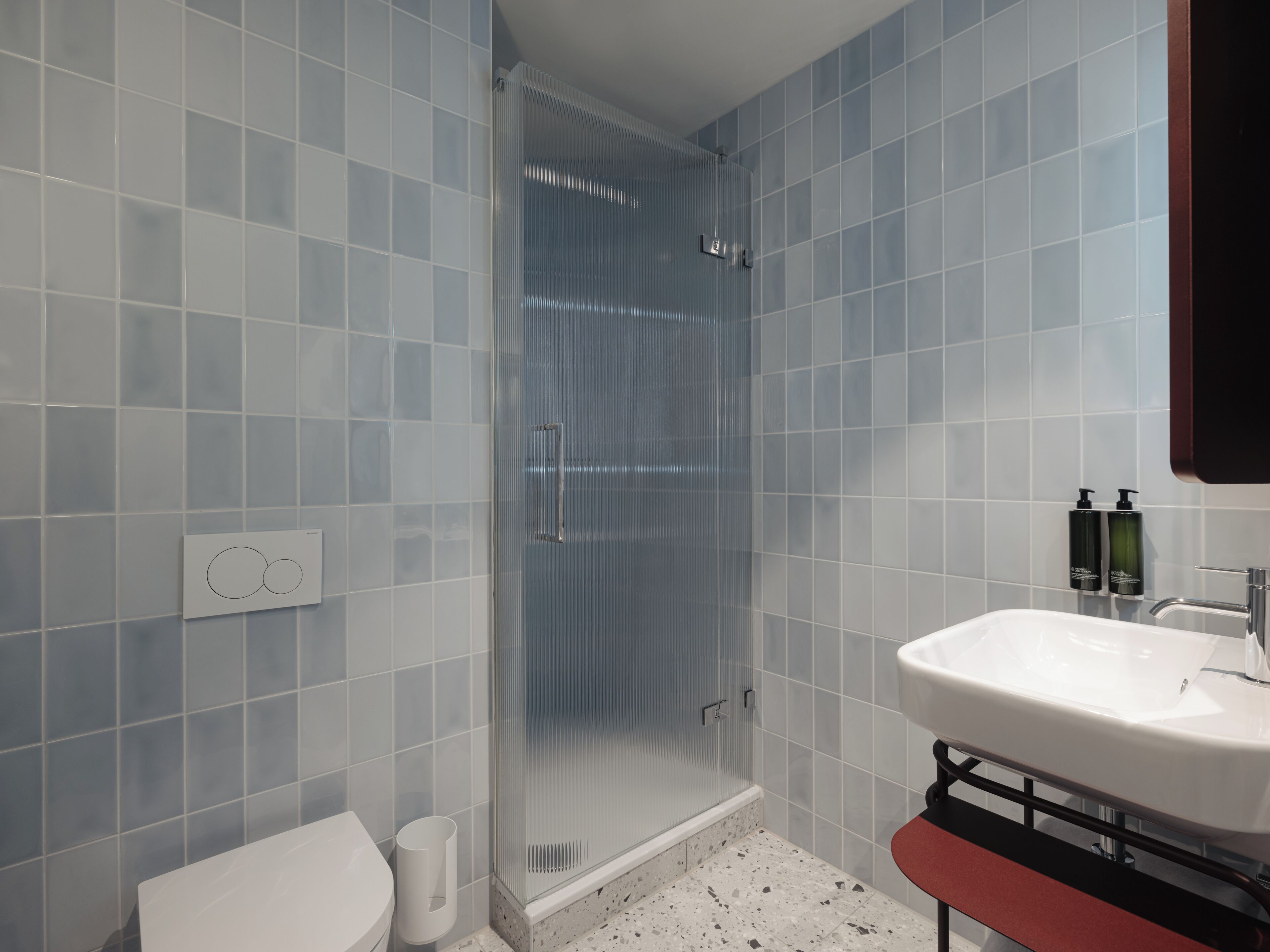 A bathroom with a shower, toilet, and sink.