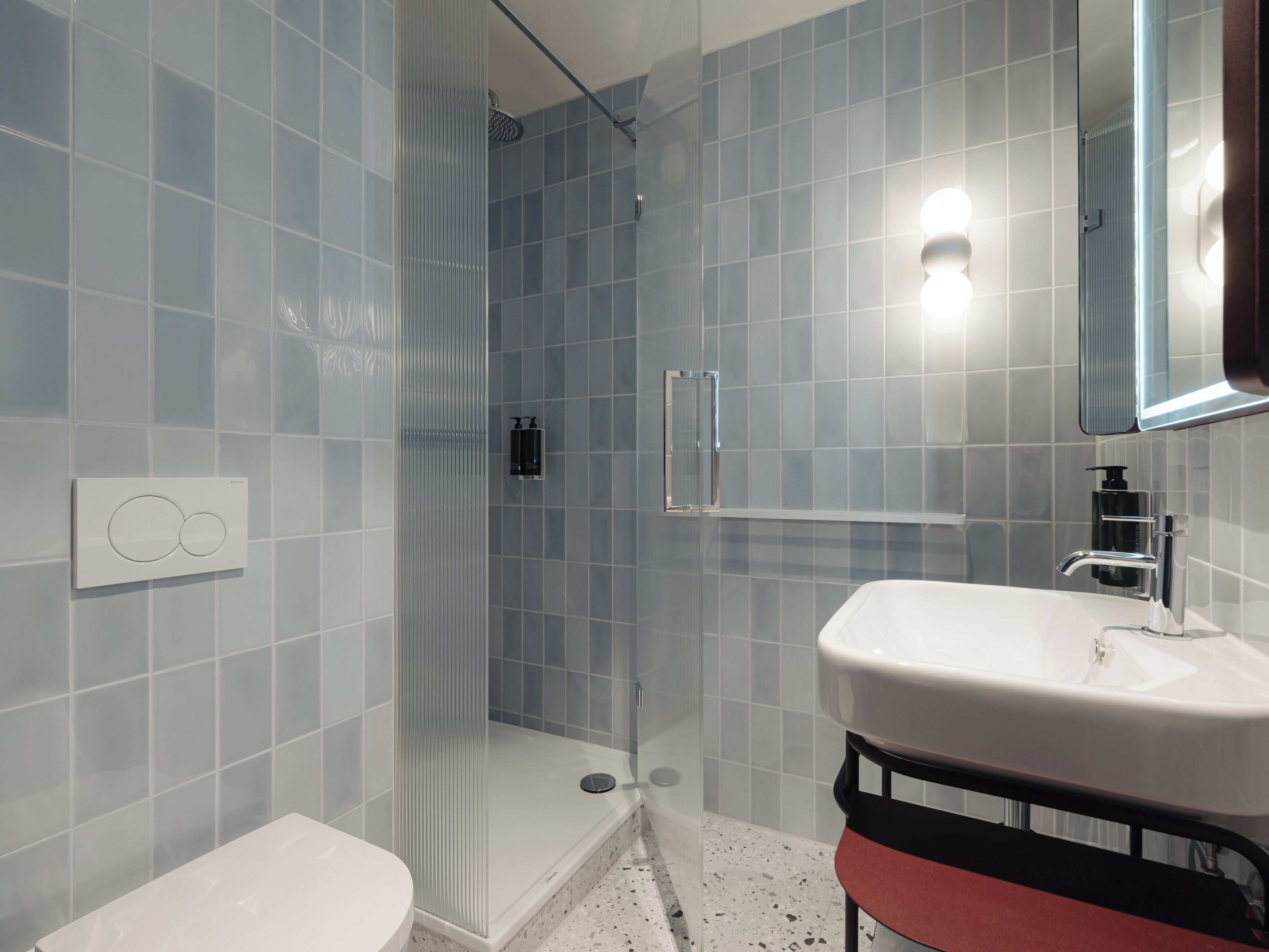 A modern bathroom with a shower, toilet, and sink.