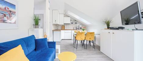 Un apartament modern amb saló, cuina i zona de menjador.