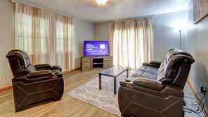 A living room with two massage chairs, a flat-screen TV, and a coffee table. - Peaceful Countryside Retreat Near Lake Barkley! (Dover)