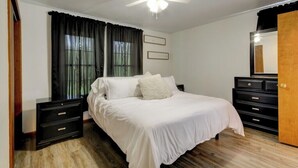 A bedroom with a bed, nightstands, a dresser, a ceiling fan, and a window with curtains. - Peaceful Countryside Retreat Near Lake Barkley! (Dover)