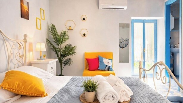 A bedroom with a bed, bedside table, lamp, potted plant, and a view of the outside. - 2 bedroom private vacation home in san feliciano, magione, perugia (San Feliciano, magione, Perugia)