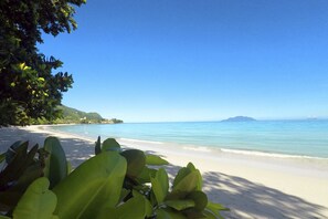 On the beach, white sand, sun-loungers, beach umbrellas