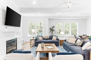 TV connectée, cheminée, livres, écrans d'ordinateur