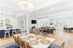 Ein geräumiges Wohnzimmer mit einer großen Couch, einem Couchtisch und einem an der Wand befestigten Fernseher.