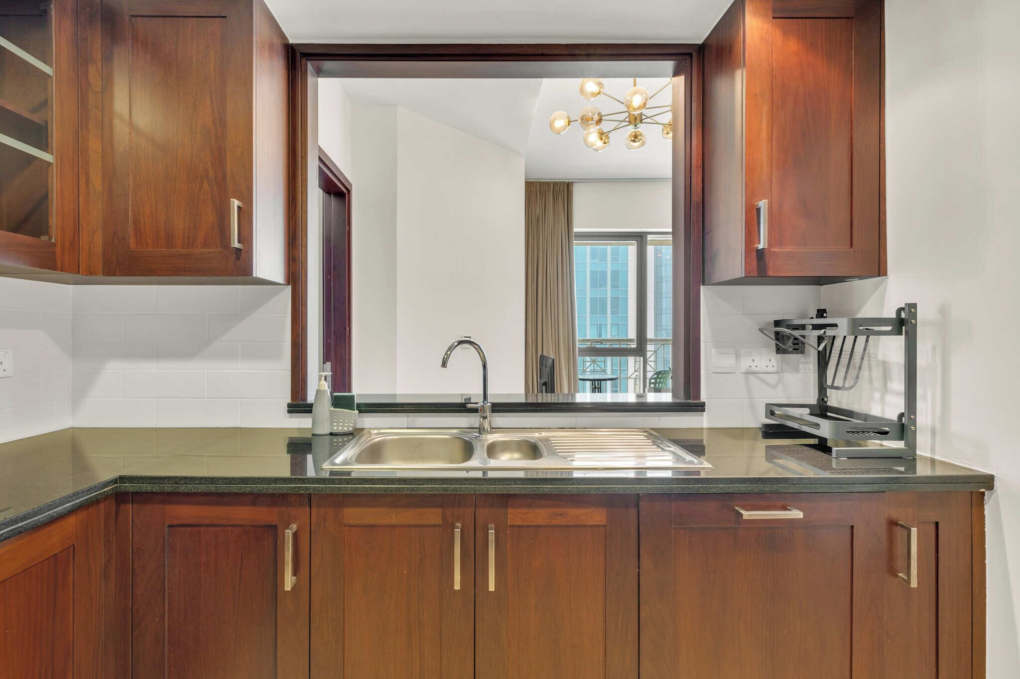 A modern kitchen with wooden cabinets, a double sink, and a built-in oven.