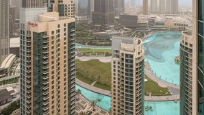 A high-rise building with a prominent tower in the center, surrounded by other skyscrapers. - Bellavista-1BR-Full BurjKhalifa&Fountain (Dubai)