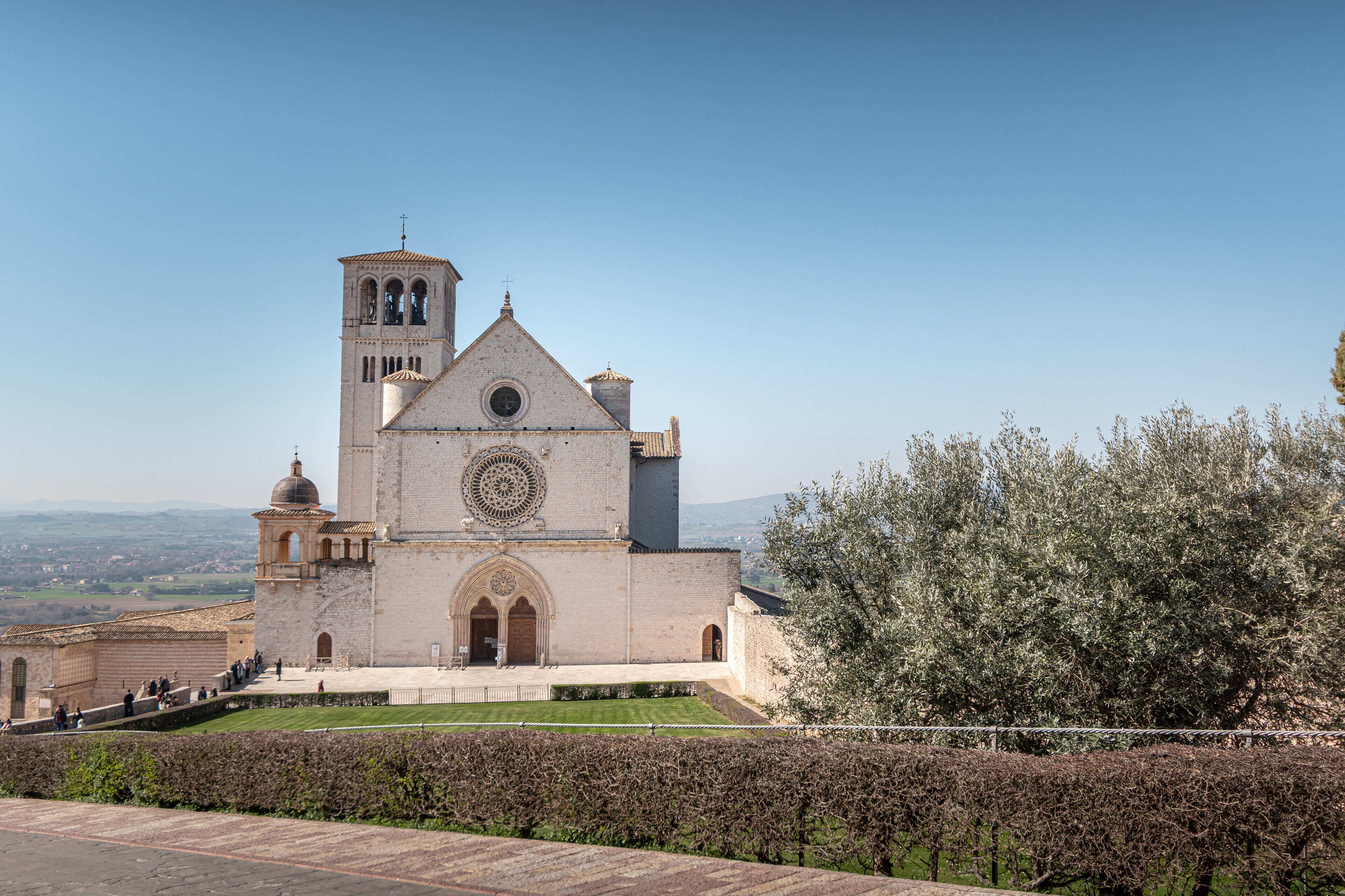Une église historique dotée d’un clocher, d’une grande fenêtre circulaire et d’une pelouse bien entretenue à l’avant.