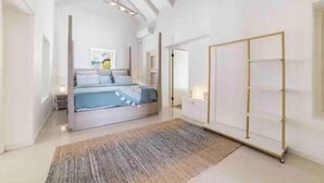 Une chambre à coucher moderne avec un lit, un grand miroir et une armoire.