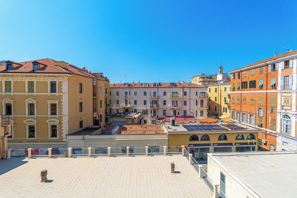 A courtyard with buildings on either side, featuring balconies and a clear blue sky. - Residence Sanremo (Sanremo)