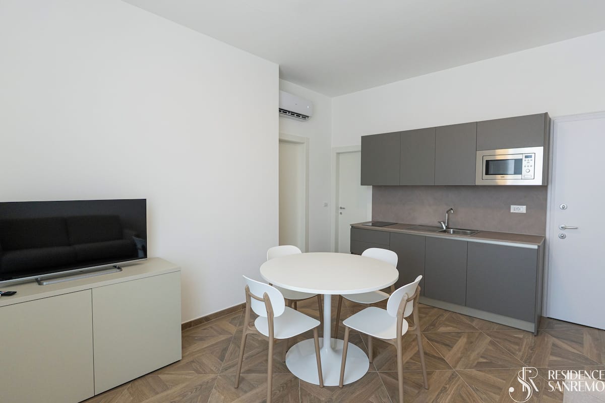 Une cuisine compacte équipée d’un four à micro-ondes, d’un évier et d’un coin repas avec une table et des chaises.