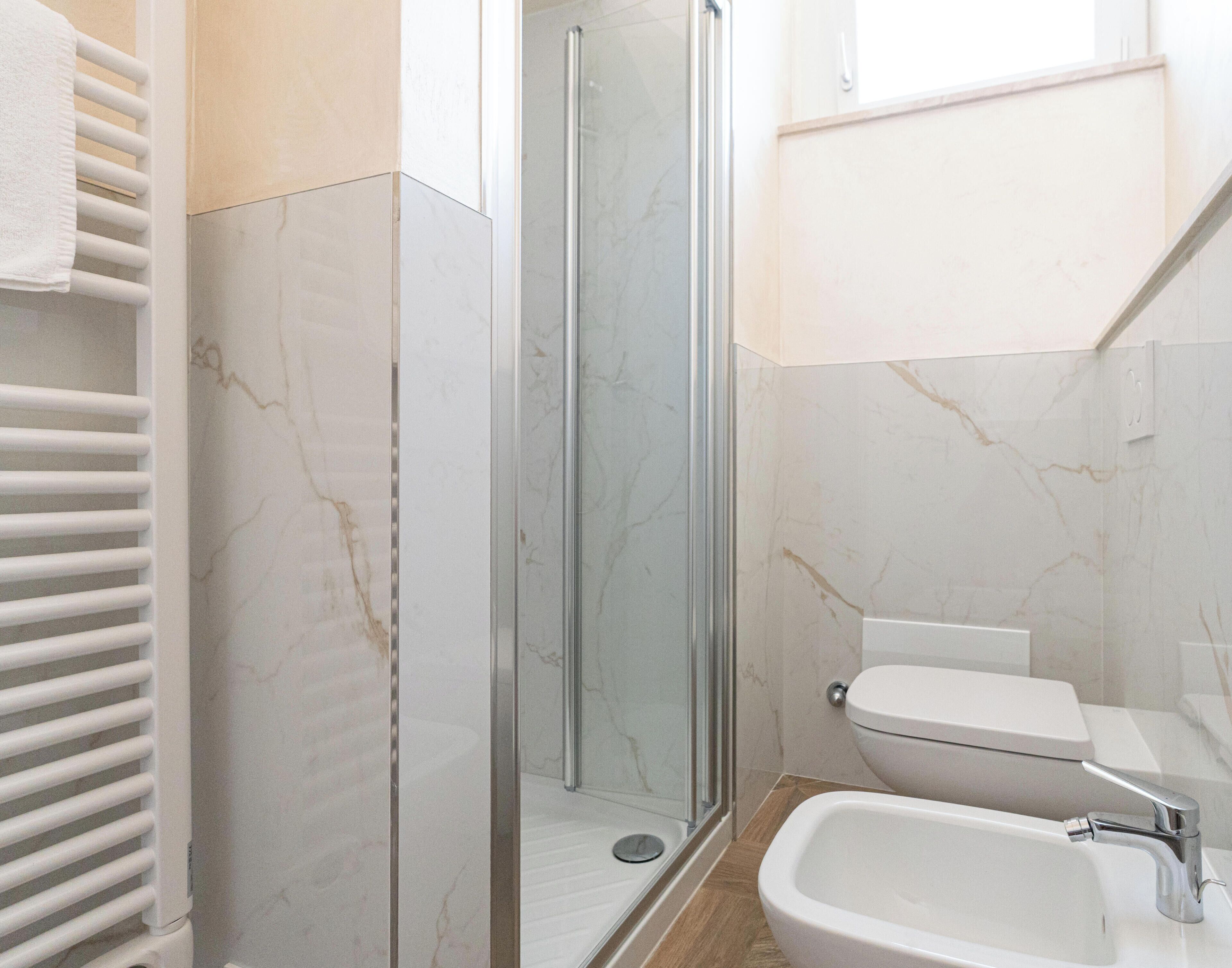 Une salle de bain moderne avec une douche à parois de verre, un lavabo blanc et des toilettes.
