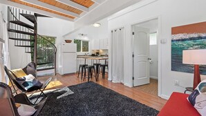 Un intérieur moderne comprenant un escalier, une cuisine, un coin repas et un salon avec vue sur l’extérieur.