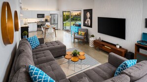 Una sala de estar moderna con un sofá modular, una mesa de centro y un televisor de pantalla plana.