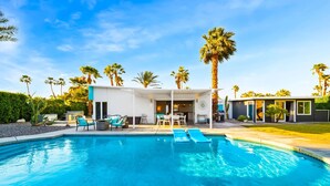 A modern pool area with a clear blue pool, lounge chairs, and a covered seating area. - 30+ Stay! W/Pool, Hot Tub, Large Patio, Ping Pong (Palm Springs)