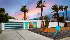 A modern house with a garage, palm trees, and a mountain backdrop. - 30+ Stay! W/Pool, Hot Tub, Large Patio, Ping Pong (Palm Springs)