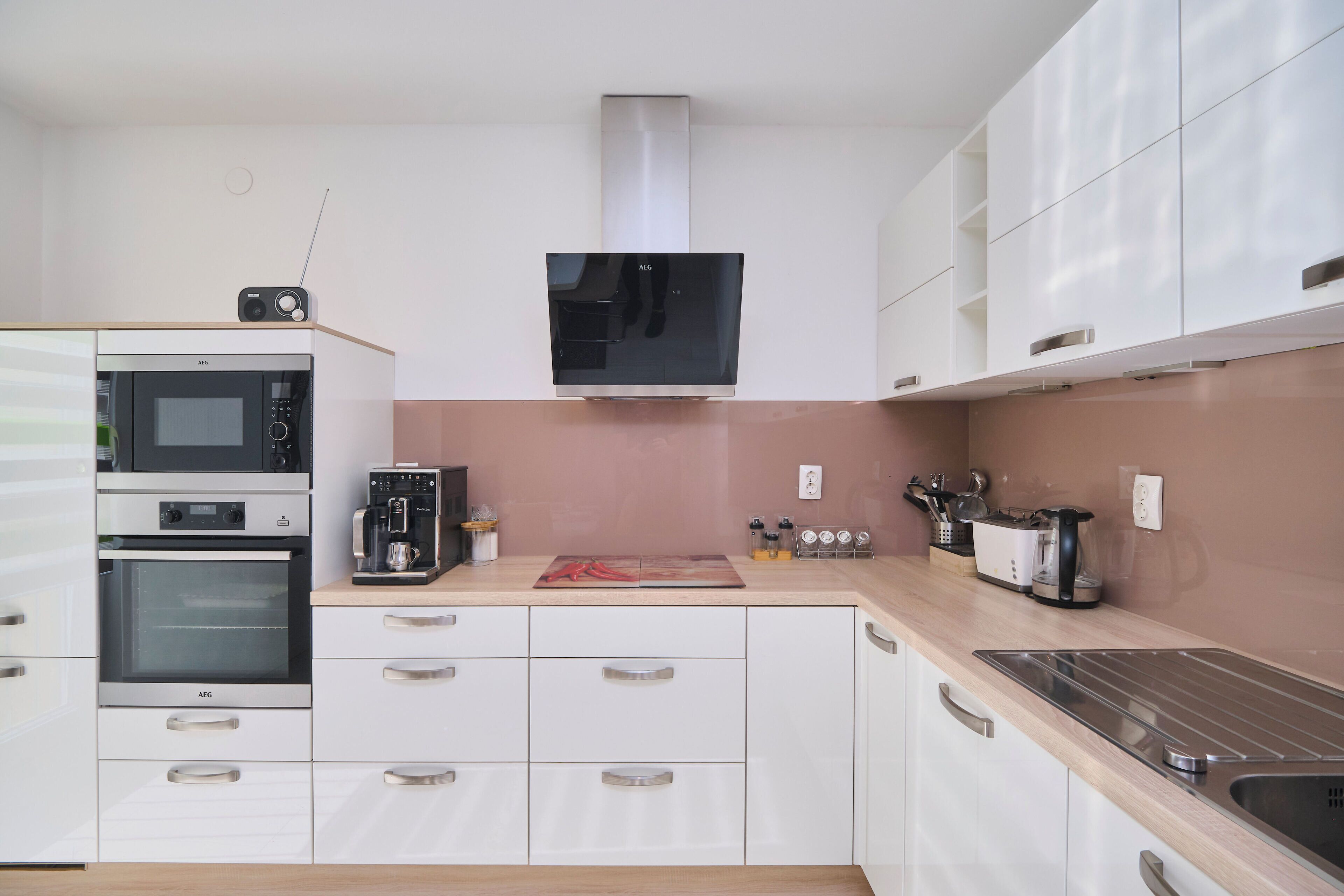 Une cuisine moderne équipée d’appareils électroménagers intégrés, d’un four à micro-ondes, d’un four et d’une machine à café.