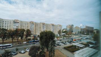 A cityscape with a large multi-story building, a parking lot, and a bus.