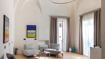 A spacious living area with a modern sofa, a dining table, and a kitchen area.