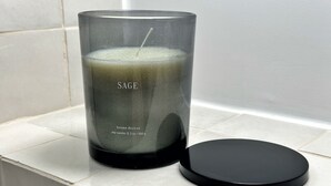 Eine Kerze mit dem Aufdruck "SAGE" und schwarzem Deckel.