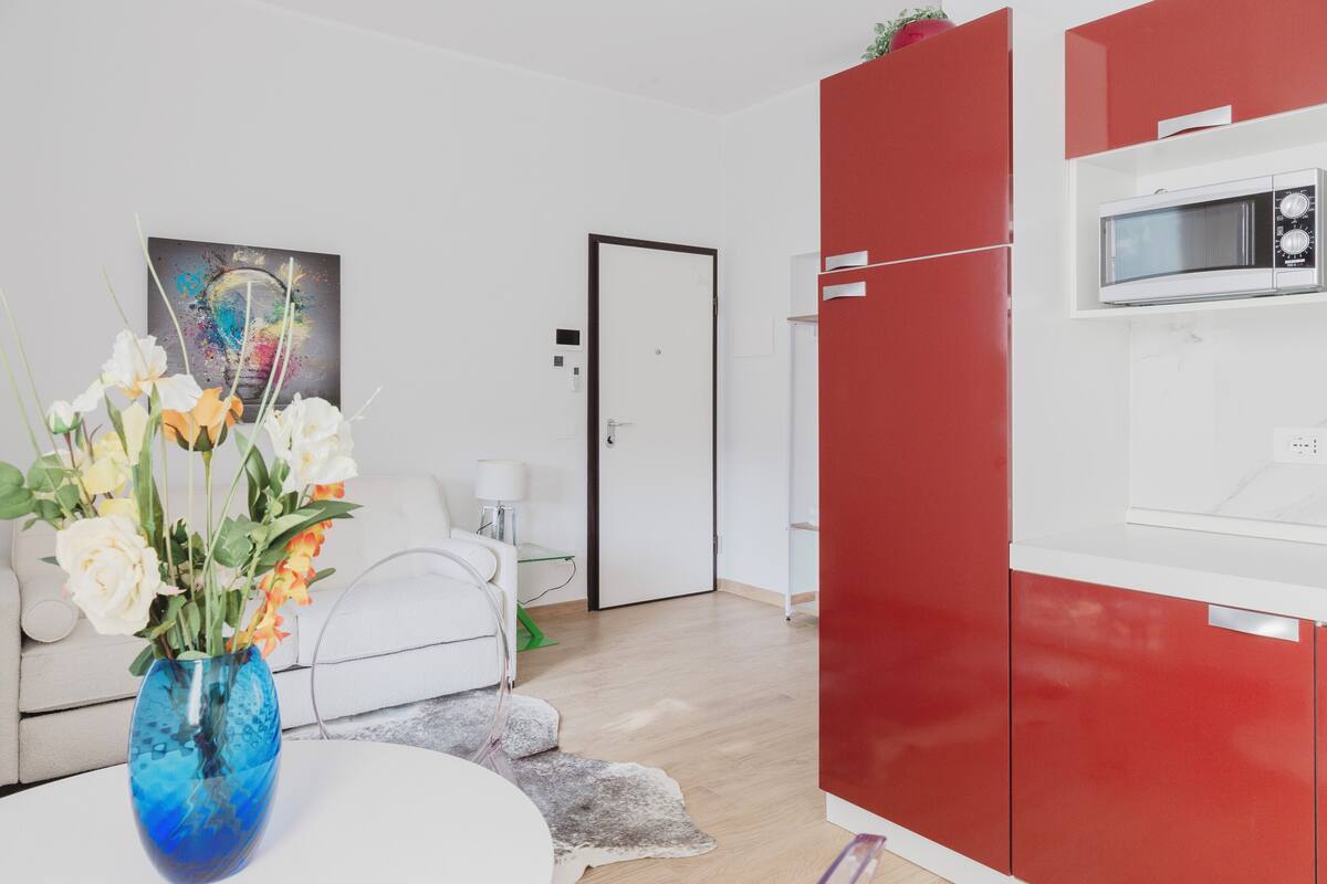 Una cocina moderna con armarios rojos, un microondas y una encimera blanca.