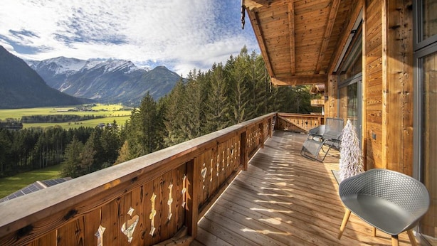 A wooden deck with a view of mountains and a valley. - Ski-friendly Chalet in Neukirchen (Neukirchen am Grossvenediger)
