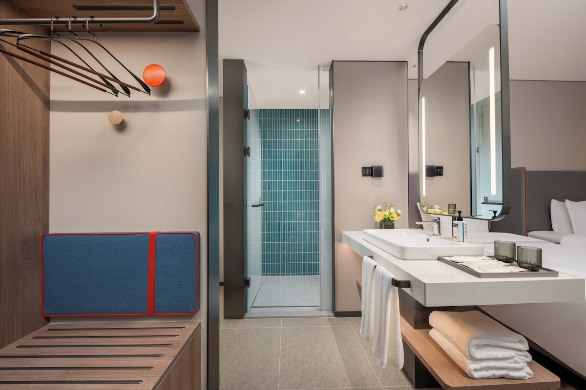 A modern bathroom with a shower, a sink, and a mirror.