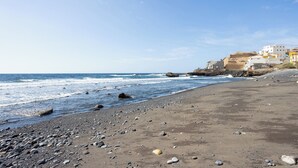 A beach with pebbles and rocks, a clear sky, and buildings in the background. - Home2Book Peaceful Apt & Sea View Terrace in Arico (Arico)