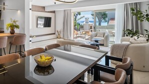 Una sala de estar moderna con comedor, ventanas grandes y vistas al exterior.