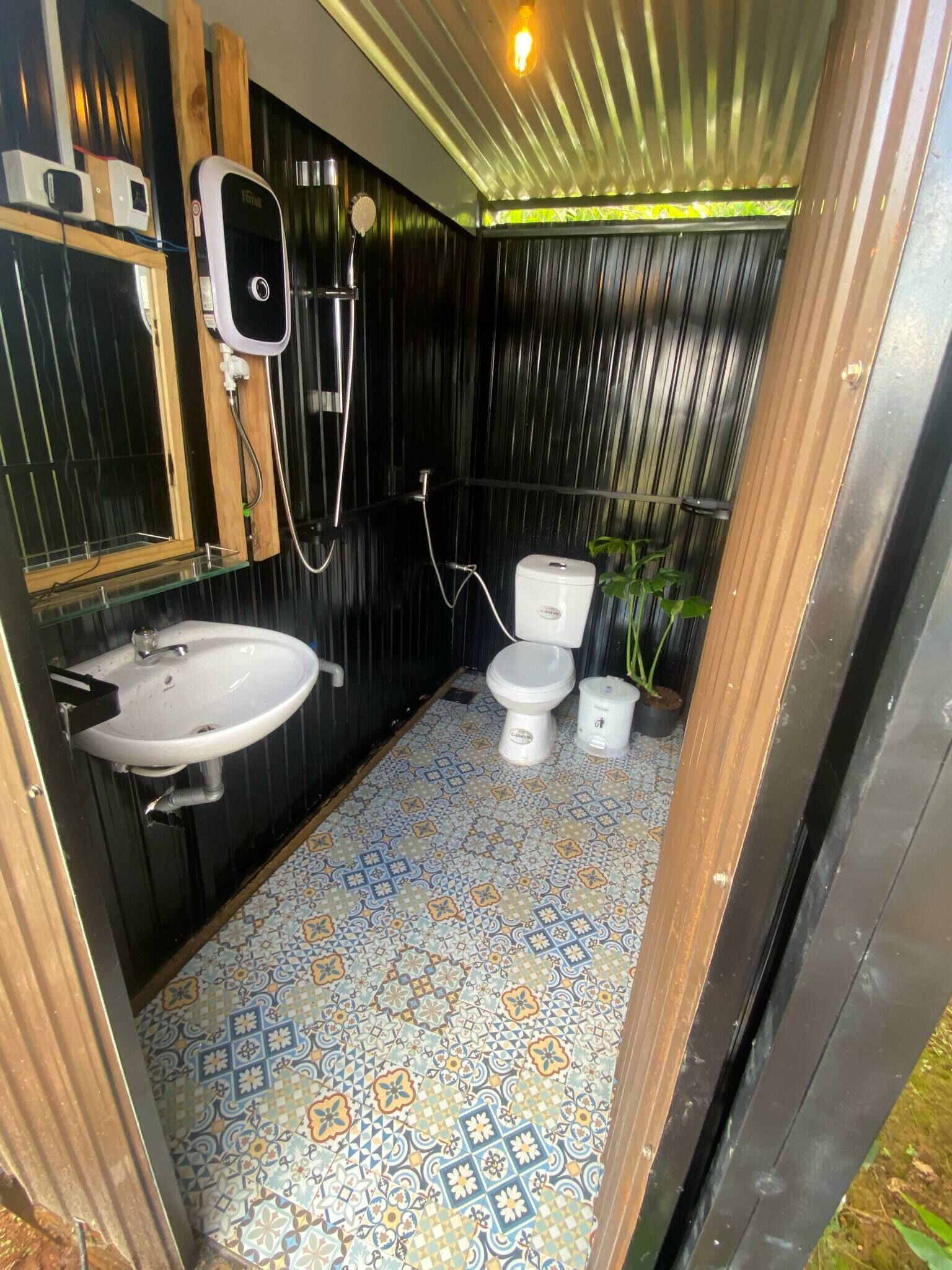 A compact bathroom with a sink, toilet, and shower.