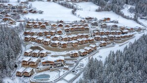 Una località turistica innevata con diversi edifici in stile chalet disposti a semicerchio.