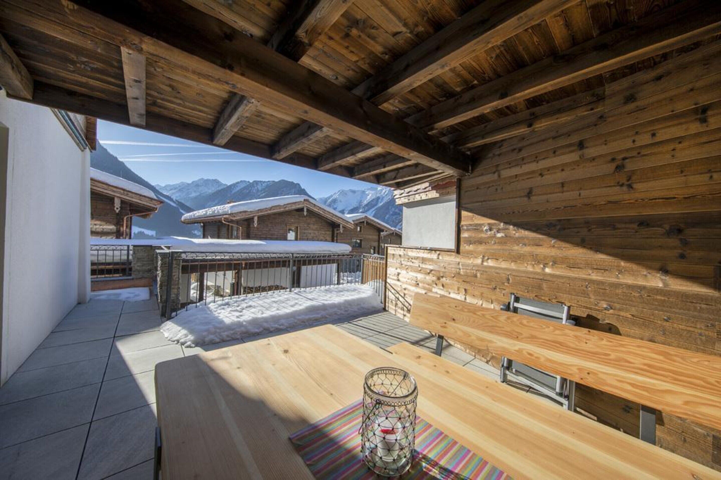A wooden interior with a view of snow-covered mountains.