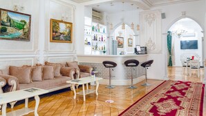 Amplia sala de estar con sofá, mesa de centro y zona de bar con taburetes.