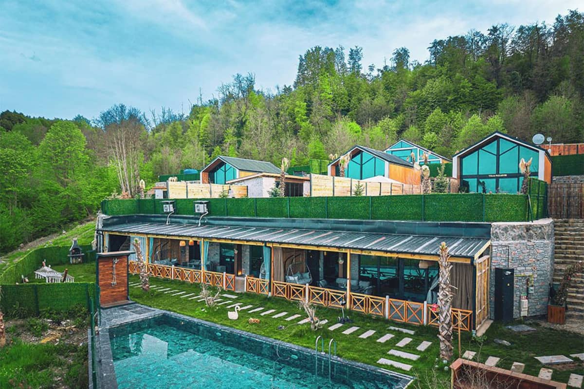 Ein modernes Resort mit Pool, mehreren Gästezimmern und einer üppigen Grünanlage.