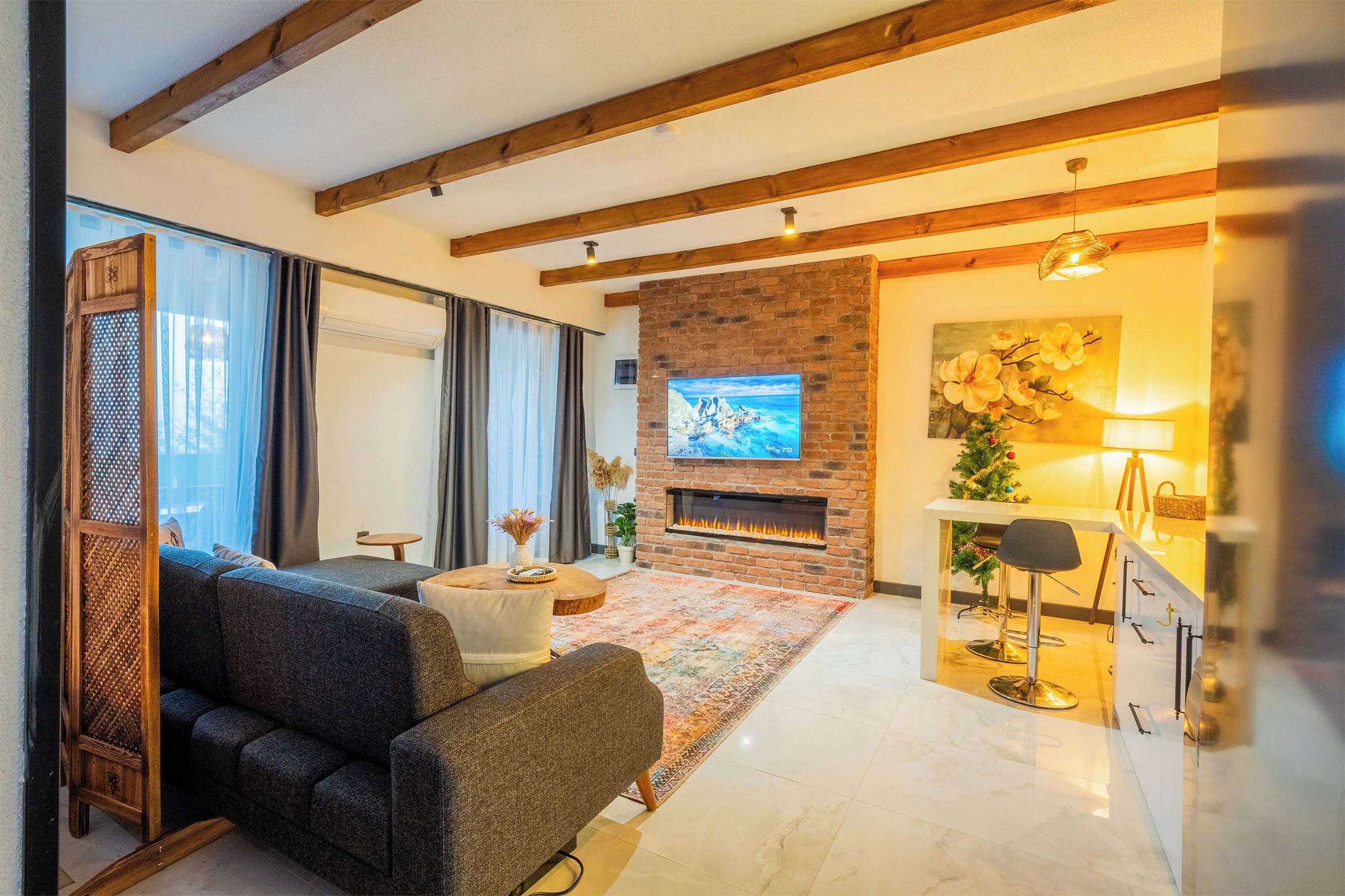 A modern living room with a fireplace, a sofa, a coffee table, and a TV.