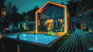 A modern villa with a glass facade, a swimming pool, and outdoor lighting. - Grand Paradise Resort (Sapanca)
