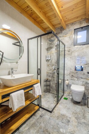 A modern bathroom with a wooden vanity, a glass-enclosed shower, and a marble-tiled floor. - Grand Paradise Resort (Sapanca)