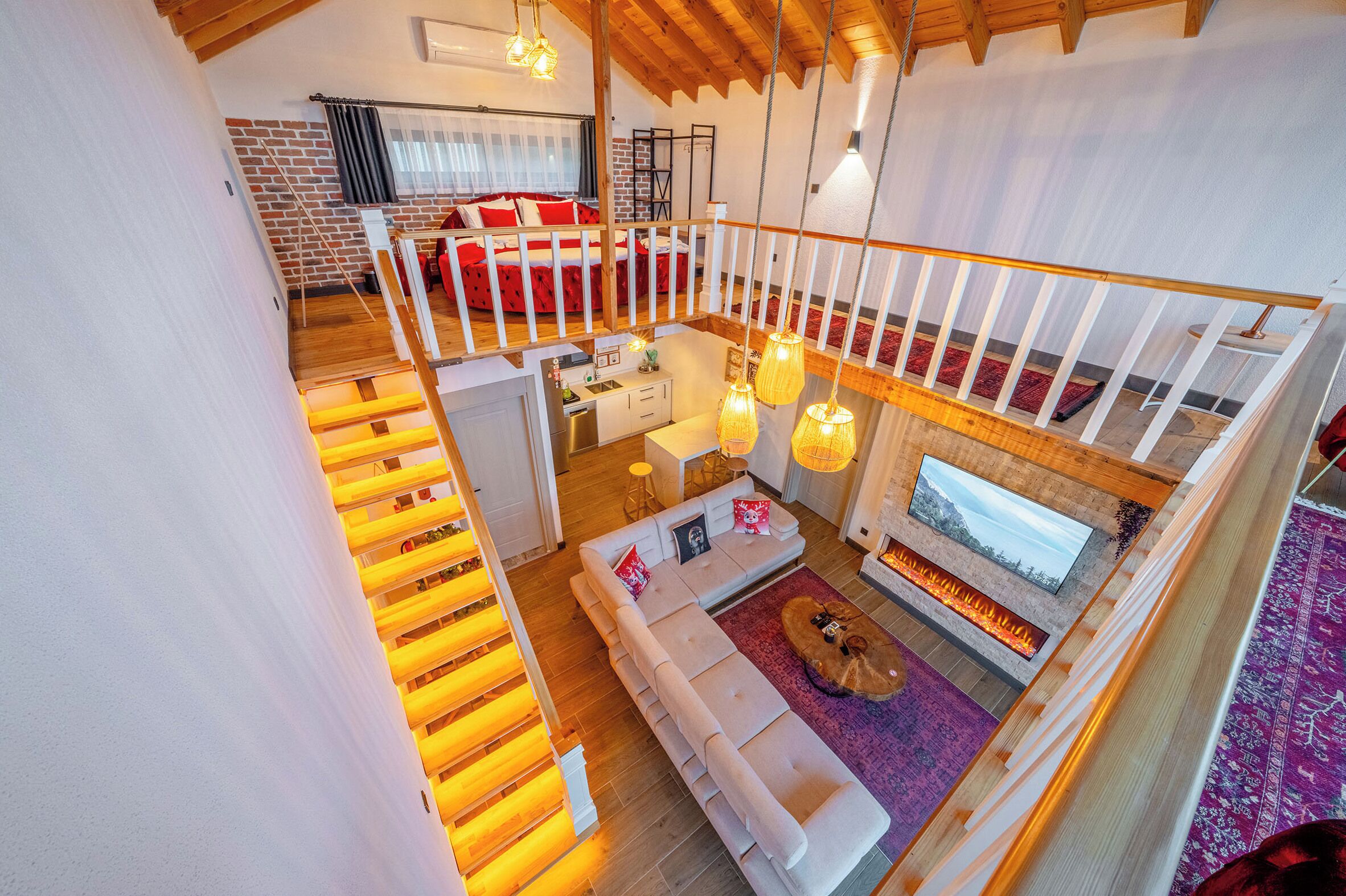 A spacious loft-style living area with a large sofa, a fireplace, and a dining area.