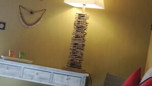 Ein Zimmer mit einem Bett, einem Nachttisch, einer Lampe und Wanddekorationen.